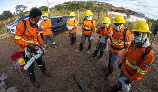 Brigadistas, em circulo, se preparam para apagar fogo.