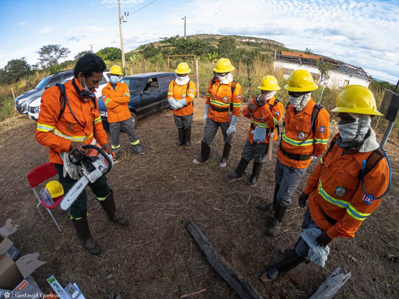 Brigadistas, em circulo, se preparam para apagar fogo.