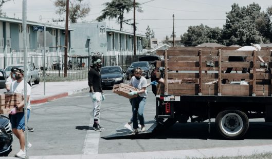 Imagem de um caminhão de alimentos sendo descarregado.